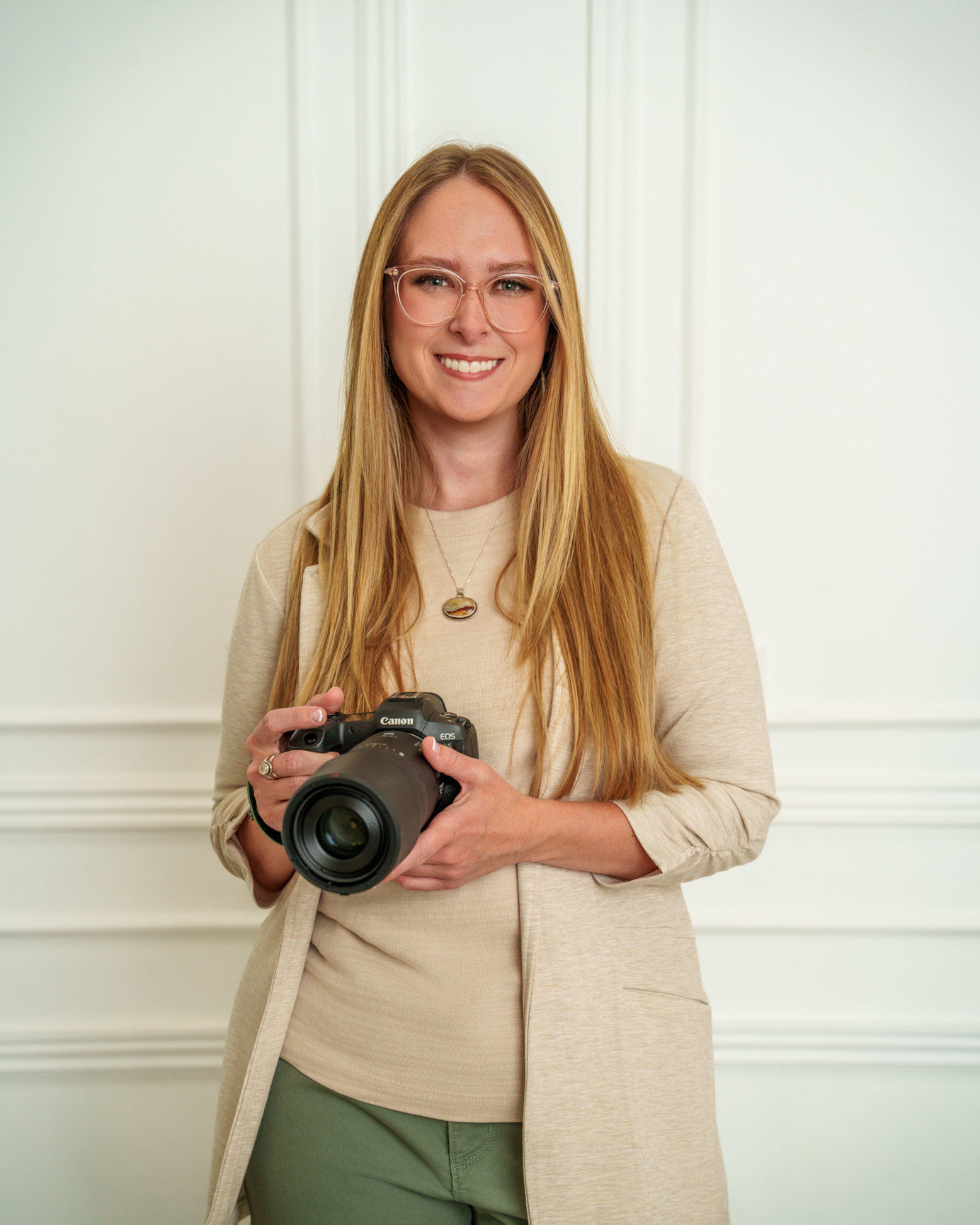 Ellie, portrait photographer and bookkeeper, holding a camera